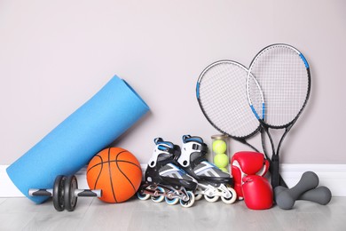 Different sports equipment near light wall indoors