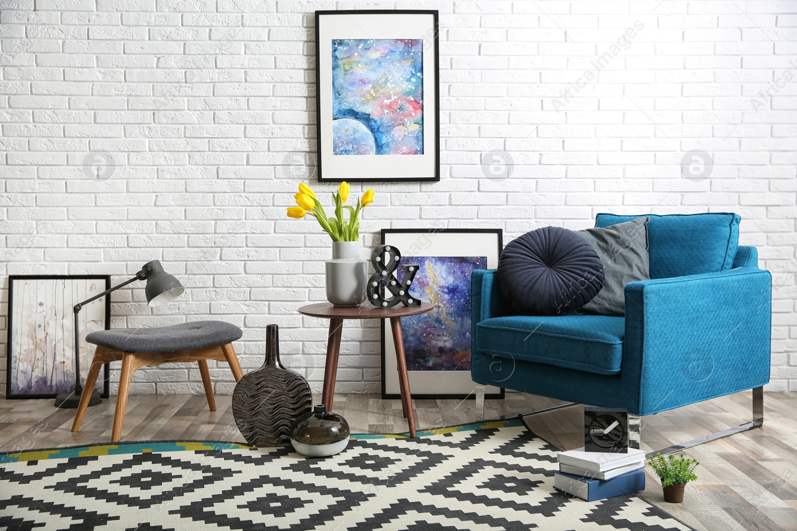 Photo of Modern living room interior with comfortable armchair and stool near brick wall