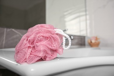Pink shower puff on washbasin in bathroom, closeup. Space for text