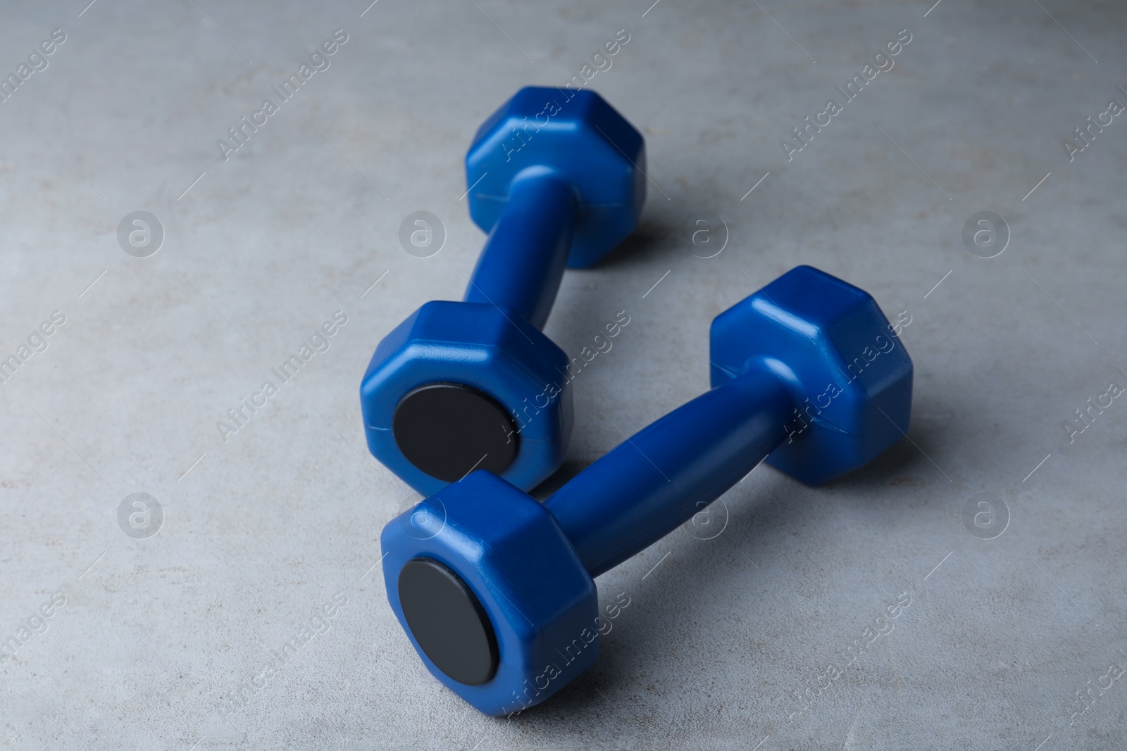 Photo of Blue vinyl dumbbells on light grey table