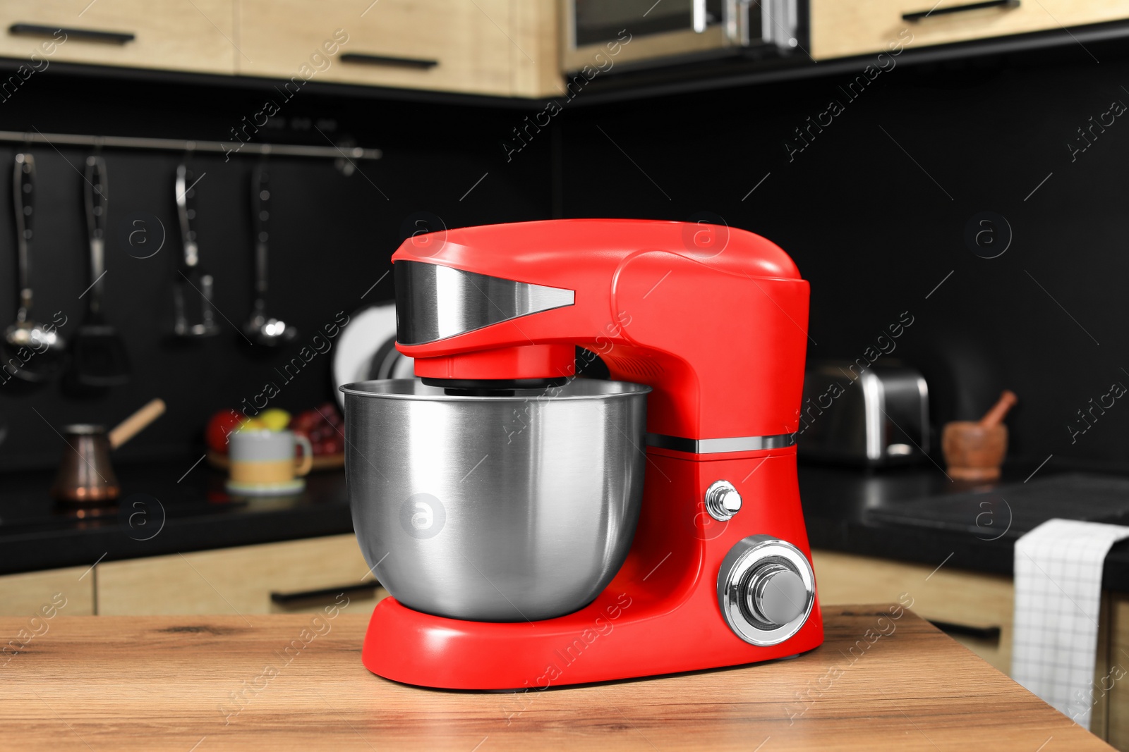 Photo of Modern red stand mixer on wooden table in kitchen