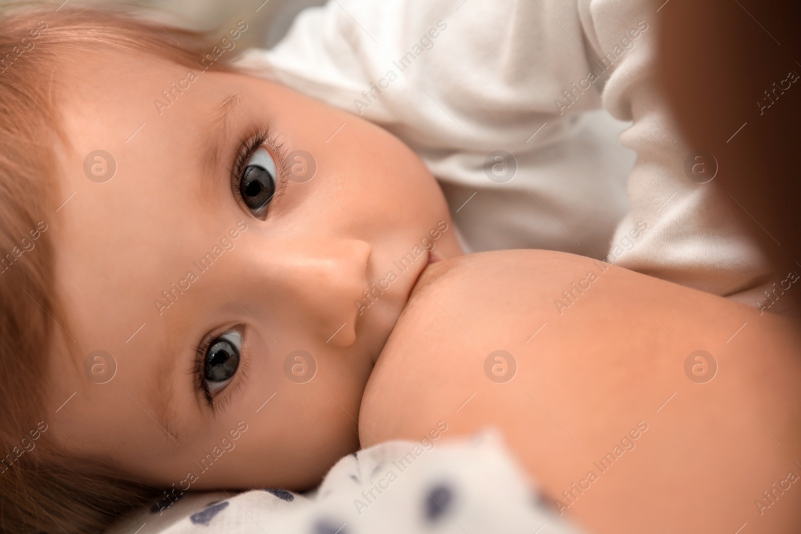 Photo of Woman breastfeeding her little baby, closeup view