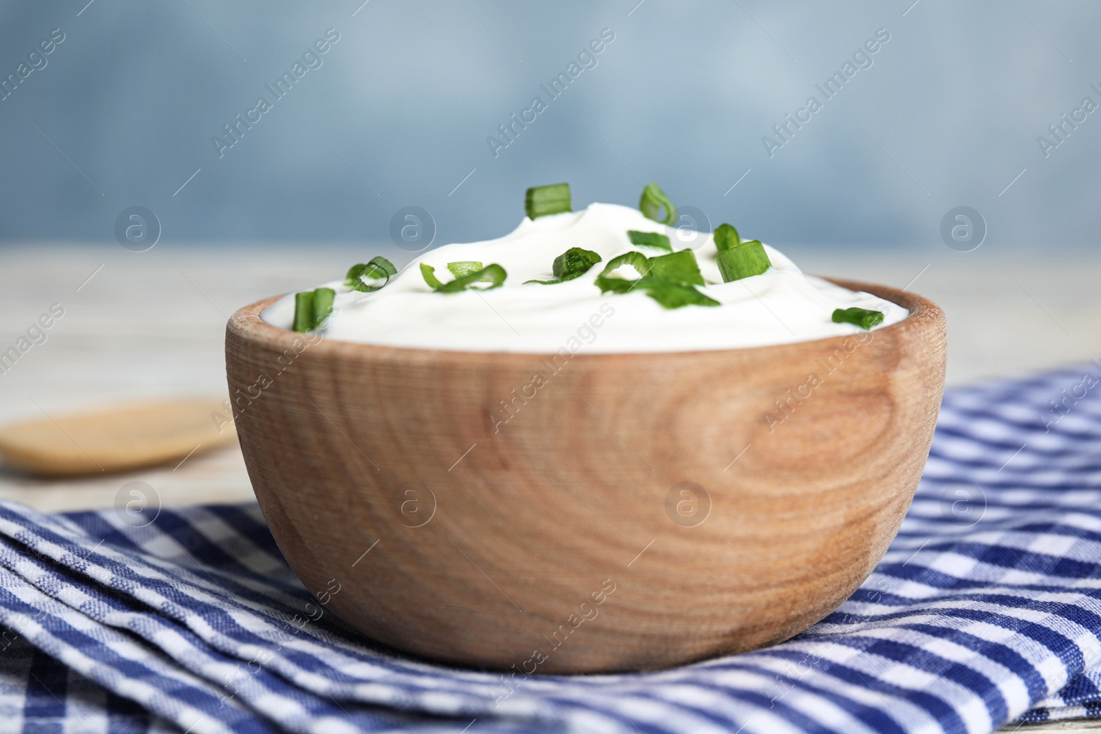 Photo of Fresh sour cream with onion on fabric, closeup