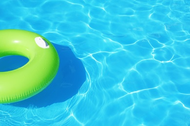 Photo of Inflatable ring floating in swimming pool on sunny day. Space for text