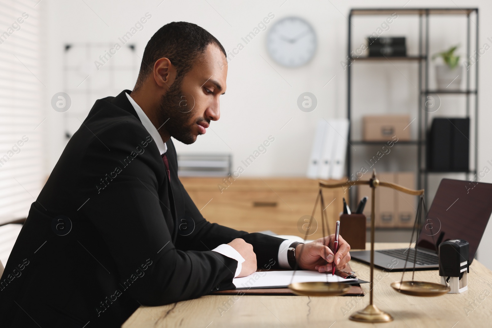 Photo of Confident lawyer working at table in office