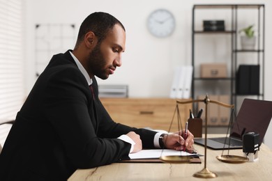 Photo of Confident lawyer working at table in office