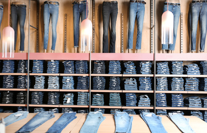 Photo of Collection of modern jeans on display in shop