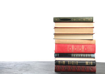 Photo of Stack of old vintage books on grey stone table against white background