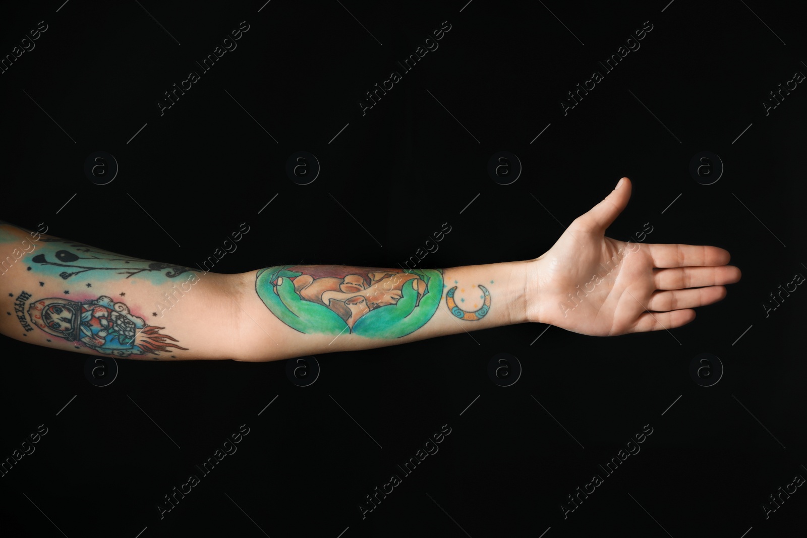 Photo of Woman with stylish tattoos on arm against black background, closeup