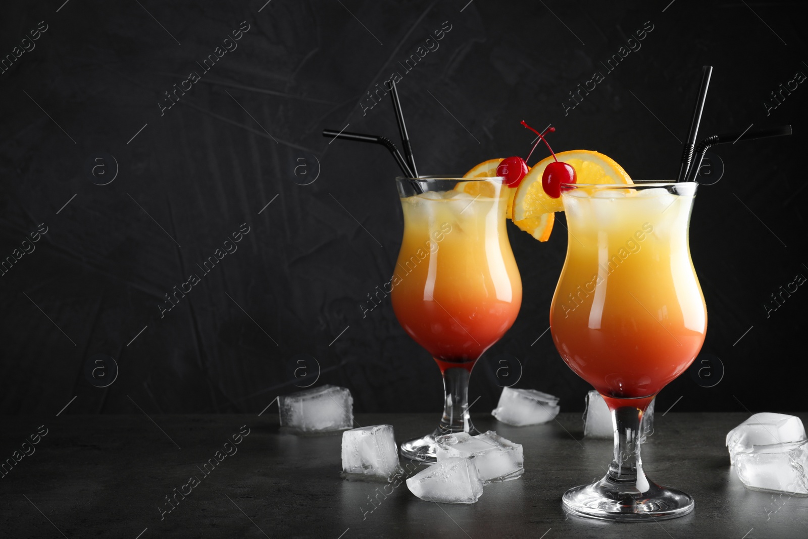 Photo of Just made appetizing cocktails Sex on the Beach, black background. Space for text