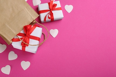 Beautiful gift boxes, paper bag and hearts on pink background, flat lay with space for text. Valentine's day celebration
