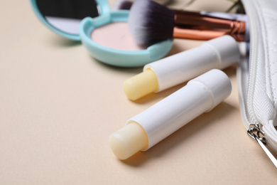 Photo of Hygienic lipsticks on light background, closeup view
