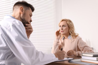 Photo of Doctor writing down patient's complaints during consultation in clinic