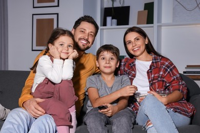 Happy family watching TV at home in evening