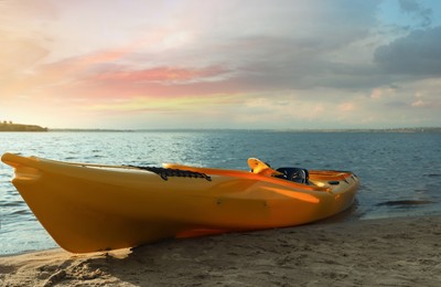 Photo of Beautiful modern yellow kayak on beach near river
