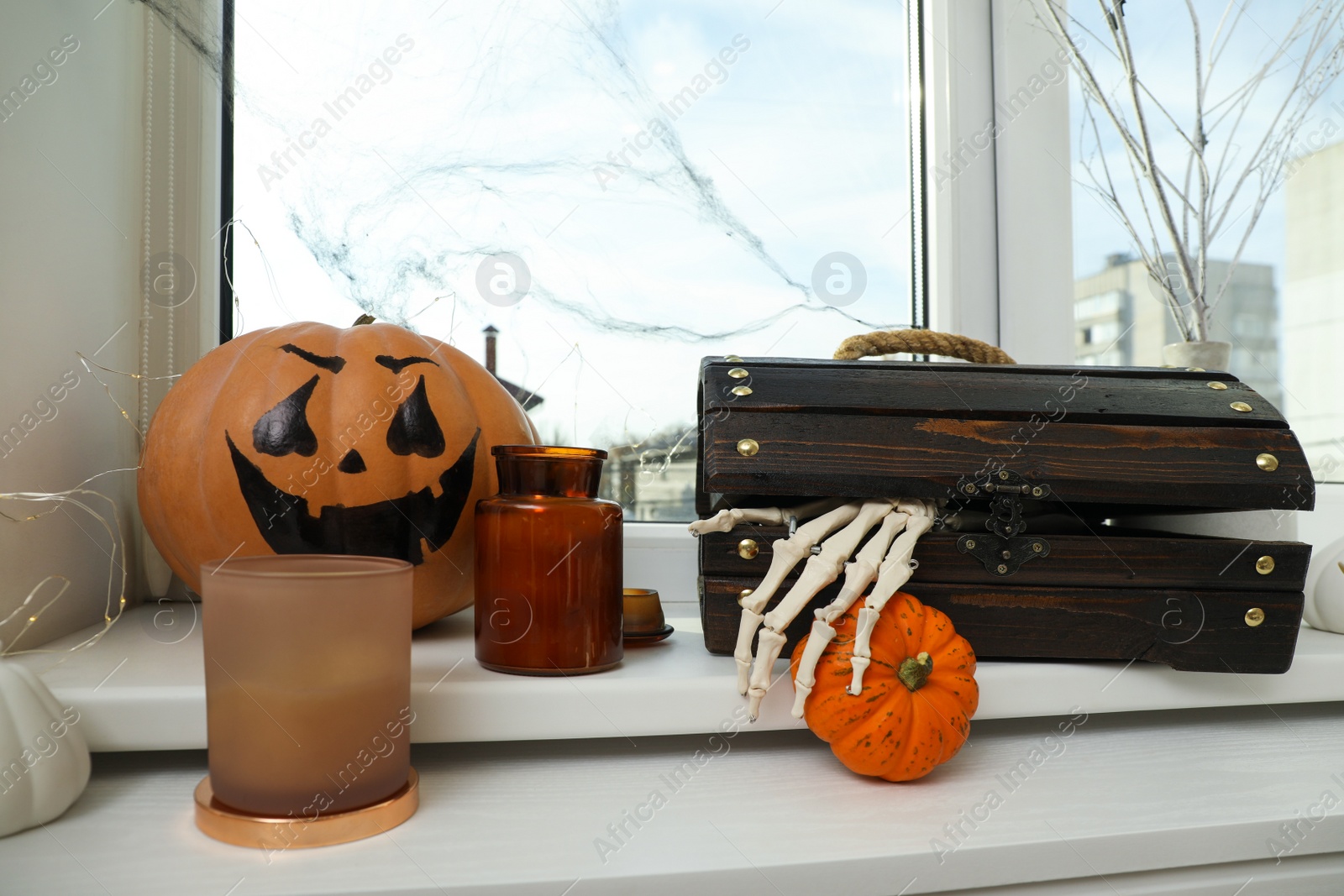 Photo of Different Halloween decor on windowsill indoors. Festive interior