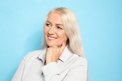 Photo of Portrait of mature woman with beautiful face on light blue background