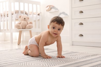 Cute baby crawling on floor at home