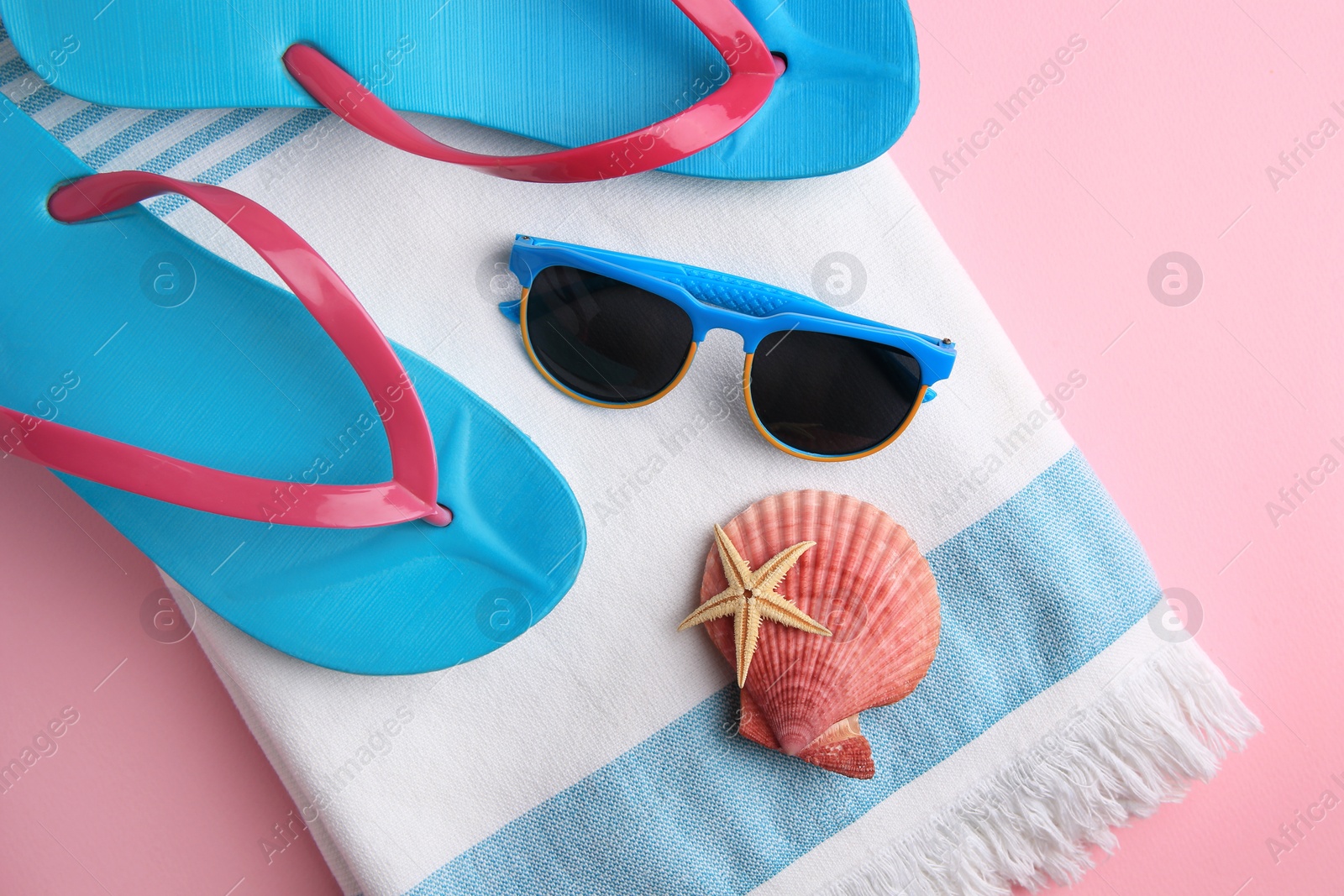 Photo of Flat lay composition with beach accessories on pink background