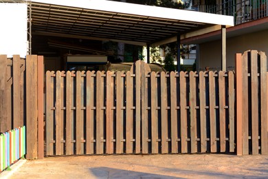 Photo of Wooden fence near house on sunny day outdoors