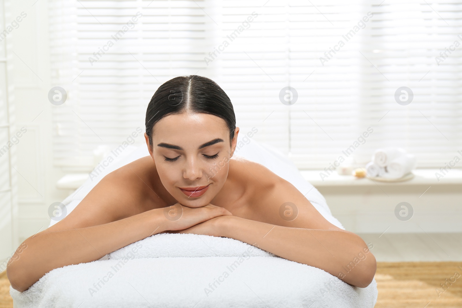 Photo of Beautiful young woman relaxing in spa salon