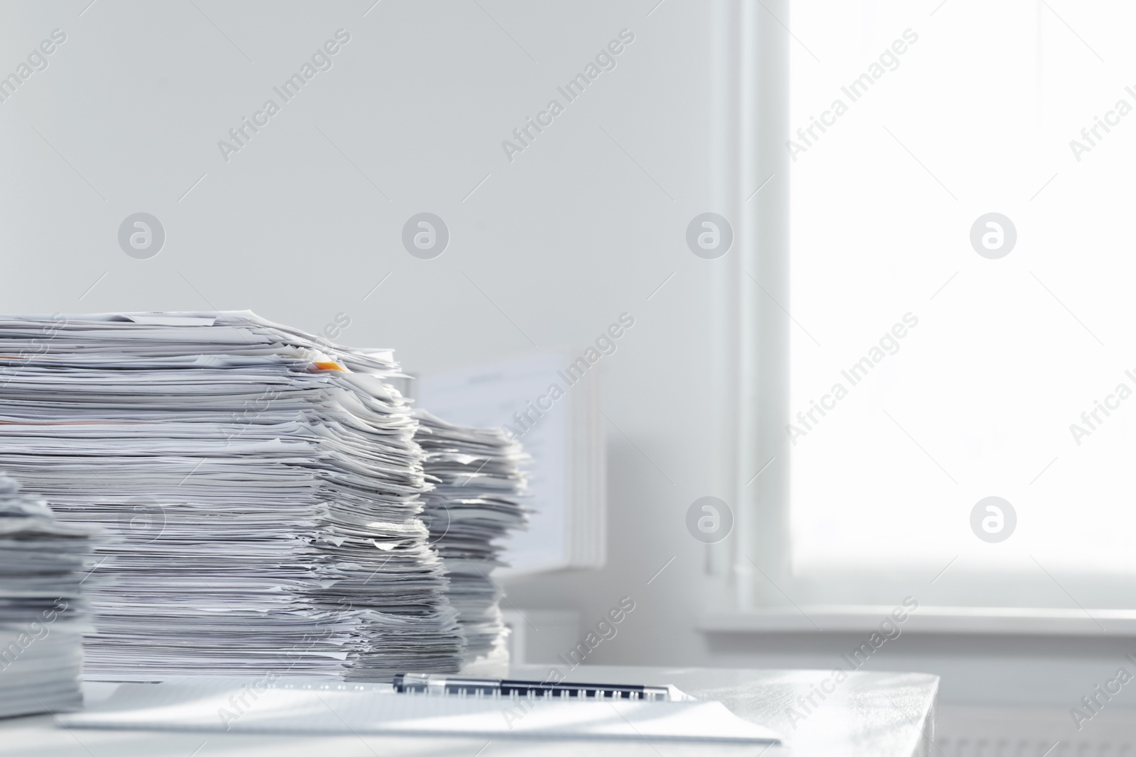 Photo of Stacks of documents on table in office. Space for text
