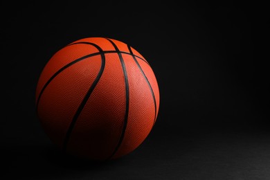 Photo of One basketball ball on black background. Space for text