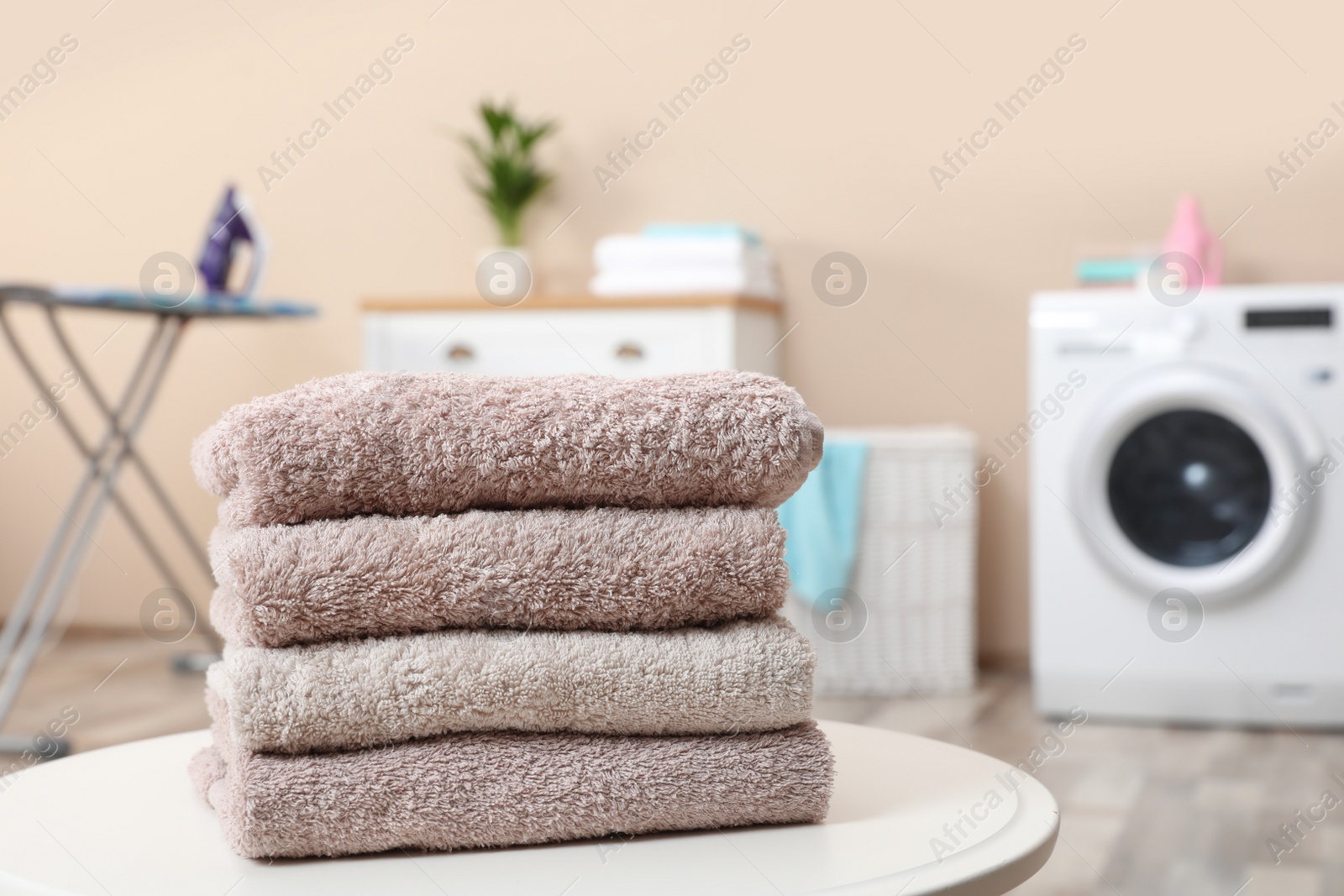 Photo of Stack of towels on table against blurred background, space for text