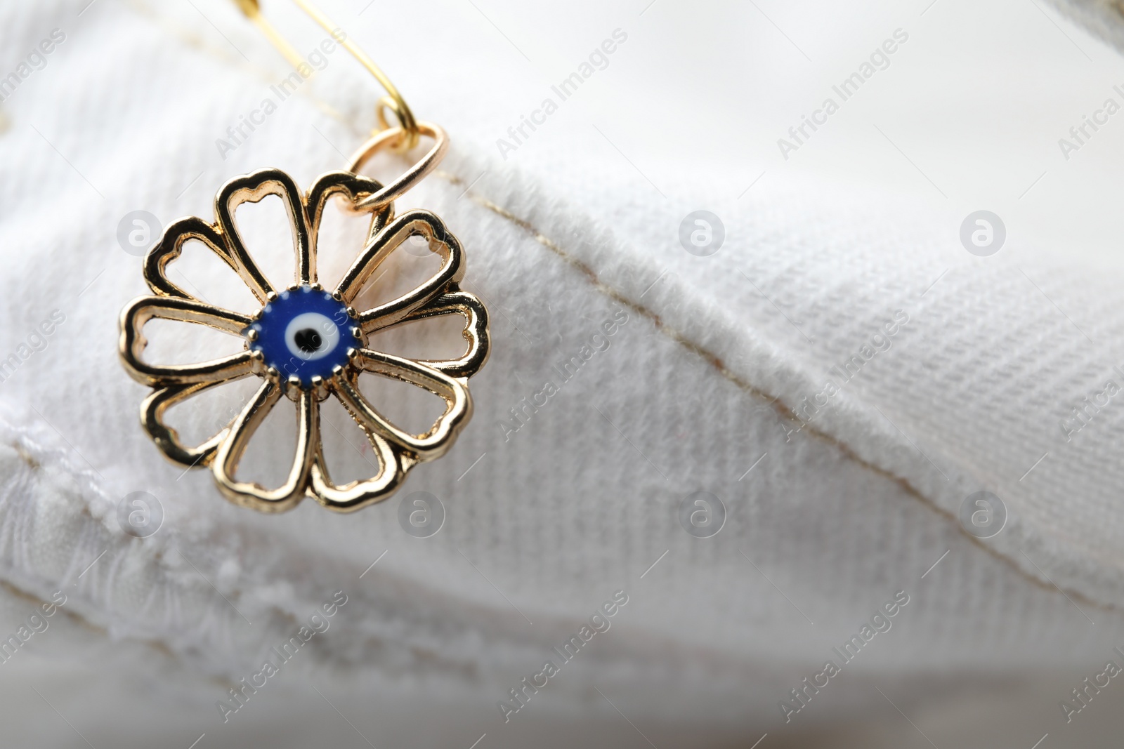 Photo of Evil eye safety pin on clothing, closeup