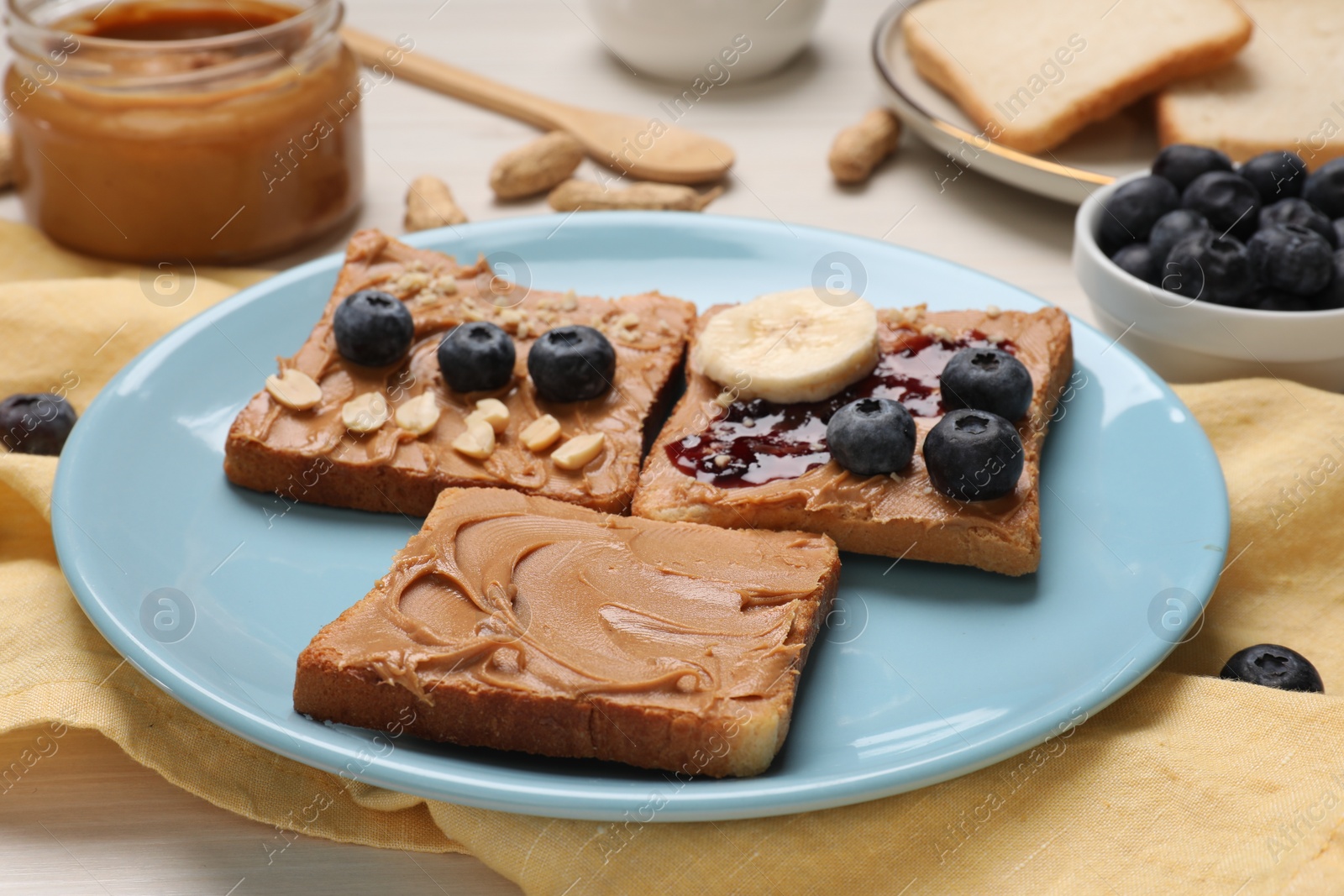 Photo of Different tasty toasts with nut butter and products on table, closeup