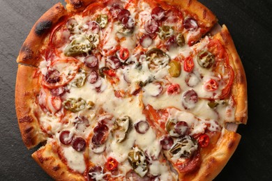 Photo of Delicious pizza Diablo on dark textured table, top view