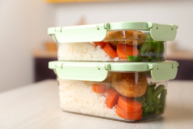 Photo of Boxes with prepared meals on table against blurred background