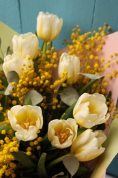 Bouquet of beautiful spring flowers near turquoise wooden wall, closeup