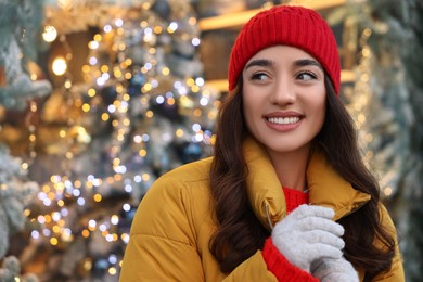 Portrait of smiling woman on blurred background, space for text. Winter time