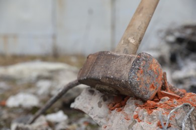 Photo of Sledgehammer on crushed brick outdoors, closeup. Space for text