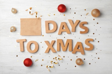 Photo of Flat lay composition with words DAYS TO XMAS and holiday decor on wooden background. Christmas countdown