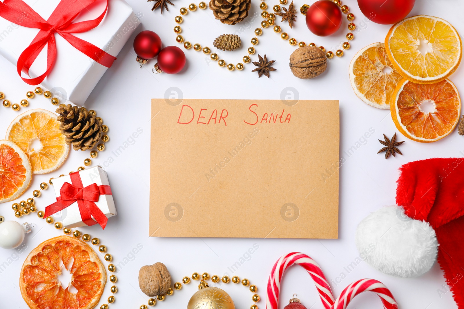 Photo of Flat lay composition with paper and Christmas decor on white background. Letter for Santa Claus