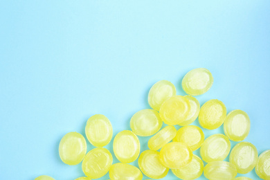 Photo of Many delicious lemon drops on light blue background, flat lay. Space for text