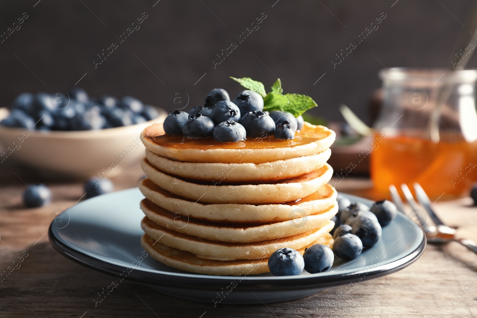 Photo of Plate with pancakes and berries on wooden table