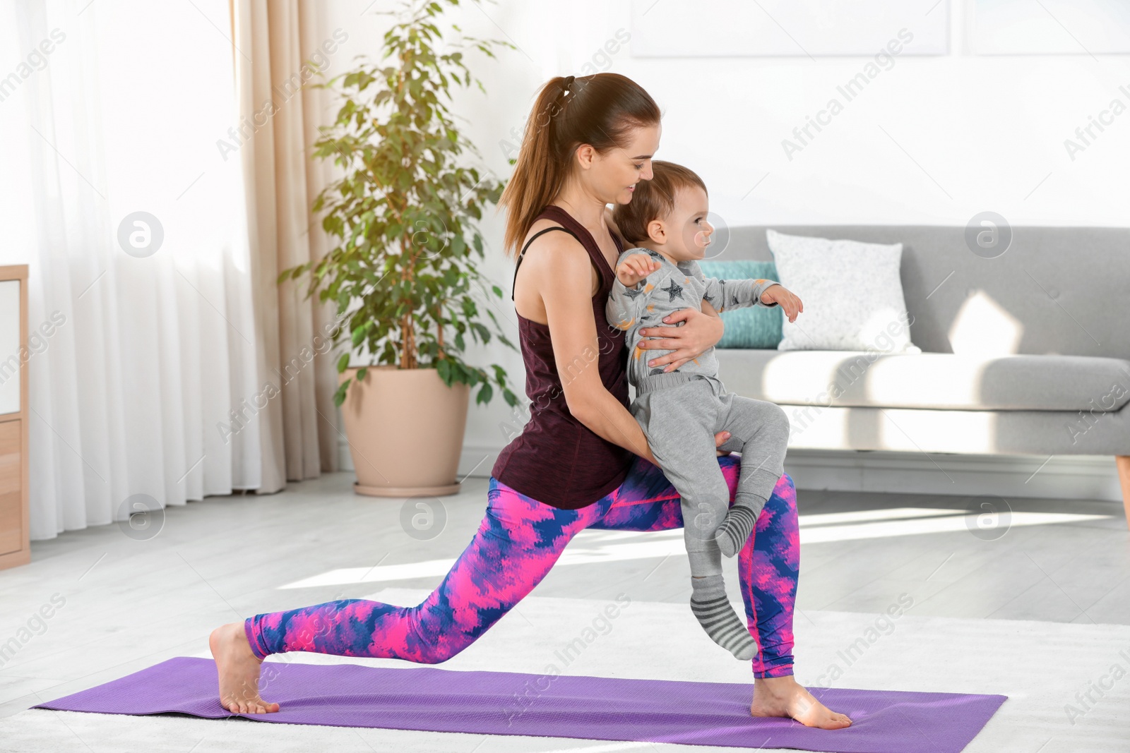 Photo of Woman doing fitness exercises together with son at home