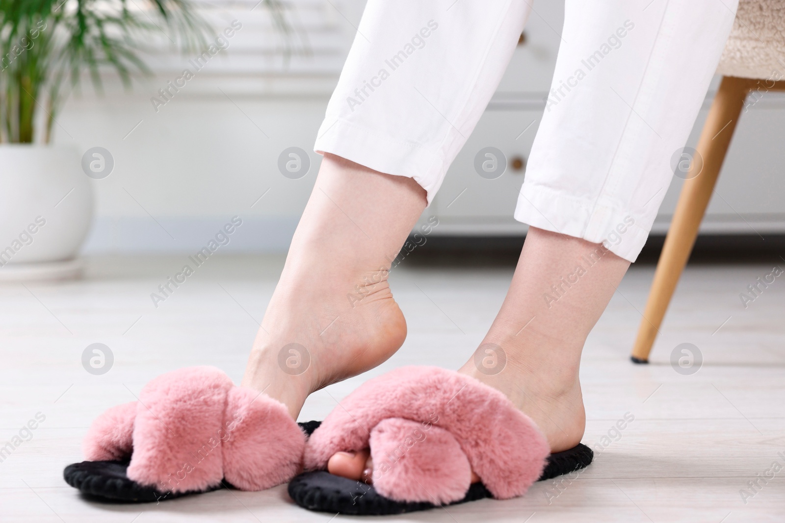 Photo of Woman in soft slippers at home, closeup