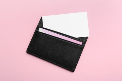 Photo of Leather business card holder with blank cards on pink background, top view