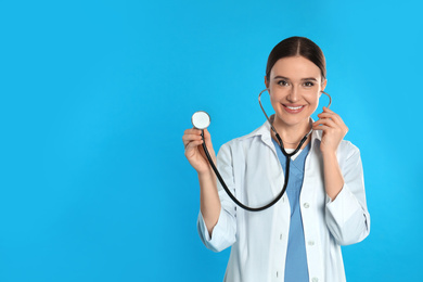 Doctor with stethoscope on blue background. Space for text