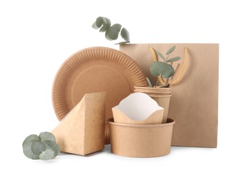 Photo of Eco friendly food packagings, disposable plate, paper bag and eucalyptus leaves isolated on white