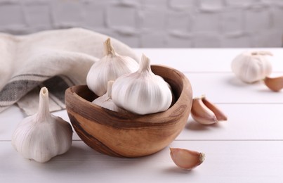 Fresh garlic on white wooden table, closeup. Space for text