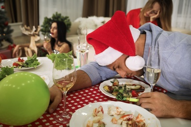 Photo of Man sleeping at table after New Year party