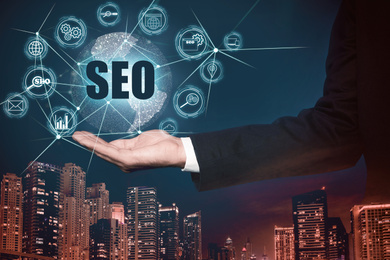Image of Man demonstrating directions of SEO, closeup. Icons of keyword research, customization and others