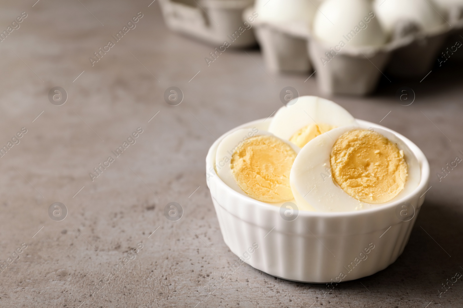 Photo of Bowl with hard boiled eggs on table. Space for text