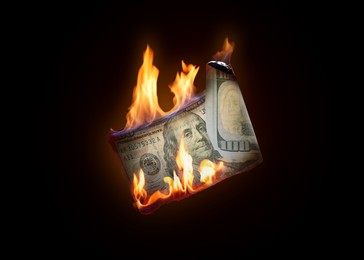 Image of One hundred dollar banknote burning on black background