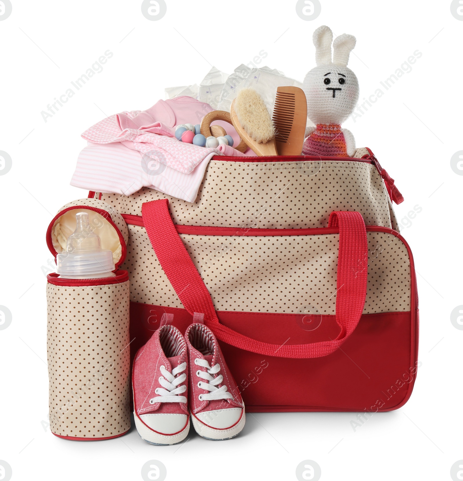 Photo of Maternity bag with child's clothes and accessories on white background